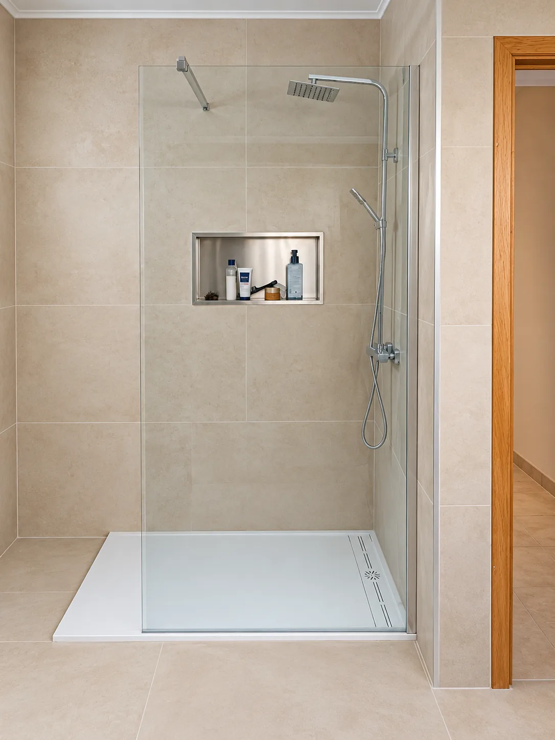 Douche avec receveur bas, paroi vitrée, niche murale et colonne chromée